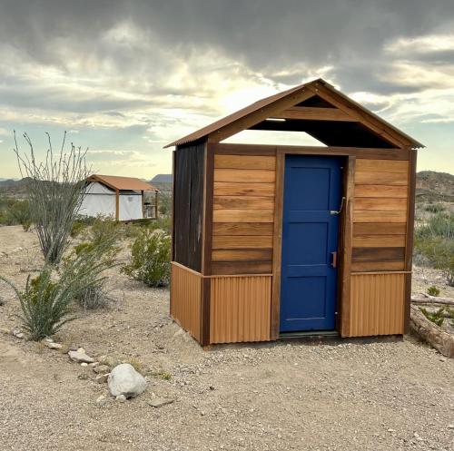 特灵瓜Rancho de los Arboles Muertos的沙漠中带蓝色门的小棚子