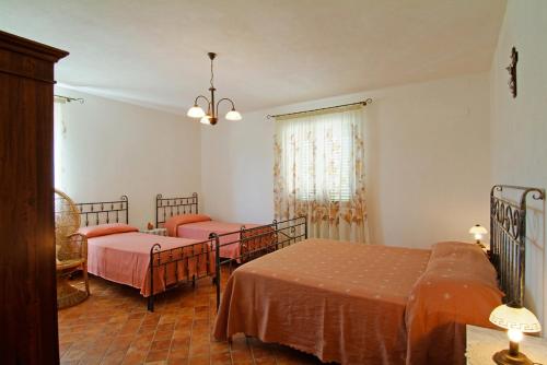 佩斯卡拉Agriturismo Il Tratturo的一间卧室配有两张床和吊灯。
