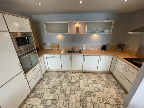 爱丁堡Corinthian Quay Apartment的享有厨房的顶部景致,厨房配有白色橱柜