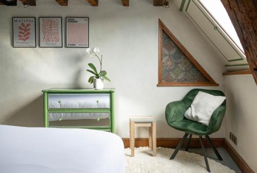 昂热Suite Toussaint - Calme & Authentique的一间卧室配有绿色椅子和一张桌子