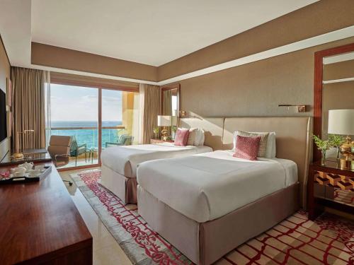 阿吉曼阿吉曼费尔蒙度假村的酒店客房设有两张床和一个阳台。