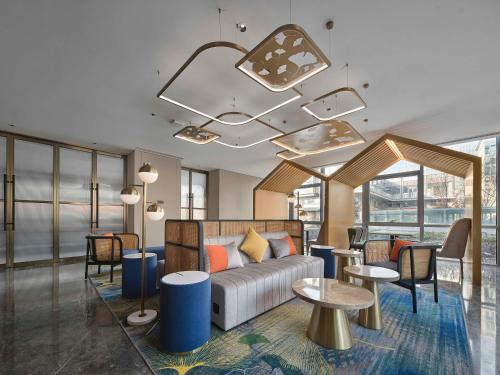 北京北京海淀稻香湖希尔顿花园酒店的酒店大堂设有沙发、桌子和窗户。