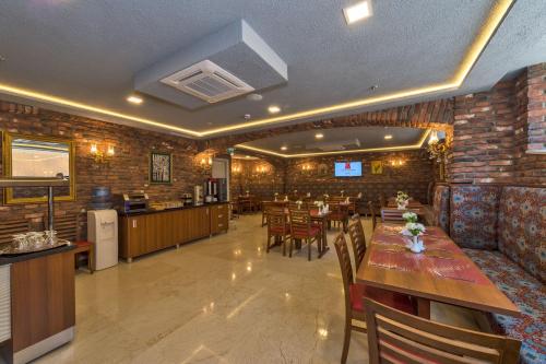 伊斯坦布尔Aprilis Gold Hotel - Special Category的一间带木桌椅的餐厅和一间酒吧