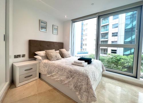 直布罗陀Luxury 1 Bed Apt - City Suites Ocean Spa Plaza的一间卧室设有一张床和一个大窗户