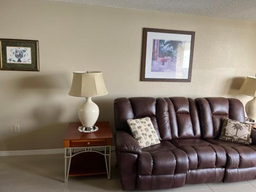 哈得逊Cozy Gulf of Mexico Resort Condo #603 in Hudson的客厅里一张棕色的皮沙发,配有灯
