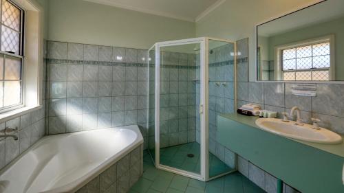 布罗肯希尔查尔斯·拉斯普汽车旅馆和别墅的带浴缸、水槽和淋浴的浴室