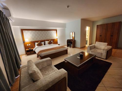 亚喀巴阿卡维斯塔套房酒店的酒店客房,配有床、沙发和椅子