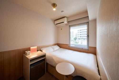 东京ホテルレジデンス大橋会館 by Re-rent Residence的小房间设有床和窗户