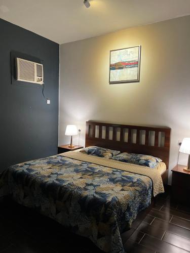 吉达Valley Villa的一间卧室配有一张床、两盏灯和一个风扇。