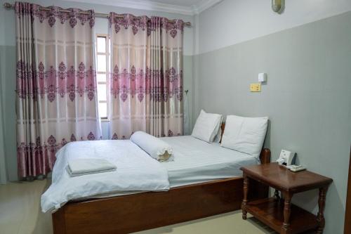 金边Empire House, Phnom Penh的一间卧室配有床和带窗帘的窗户