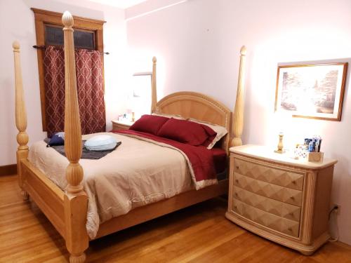 马里恩Beatrice The Villa的一间卧室配有四柱床和床头柜