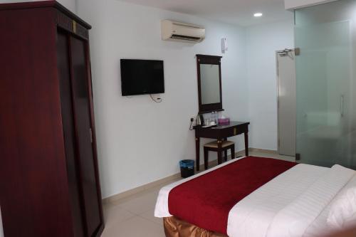吉隆坡Hotel AL Amin的卧室配有一张床,墙上配有电视。