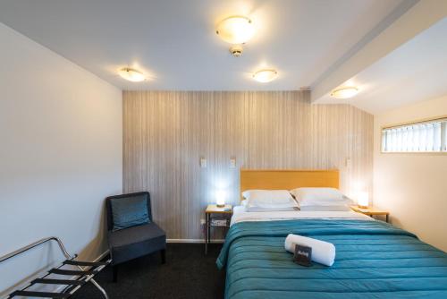 基督城里卡顿罗马汽车旅馆的配有一张床和一把椅子的酒店客房