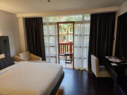 碧瑶The Forest Lodge at Camp John Hay with balcony and parking privately owned unit 272的酒店客房设有一张床、一张书桌和一个阳台。