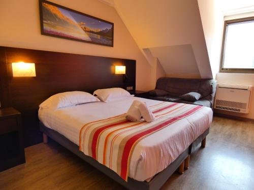里摩日Hotel Be Guest Limoges Sud - Complexe BG的一间卧室配有一张床,床上有毛巾