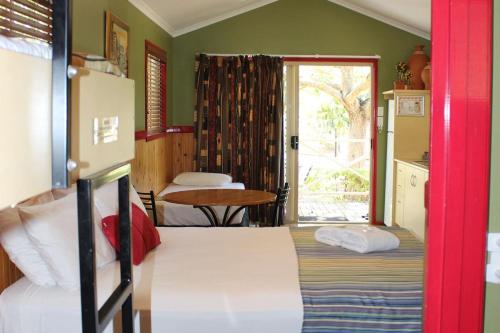 查特斯堡澳大利亚内陆绿洲度假公园四大酒店的一间卧室设有两张床、一张桌子和一个窗口