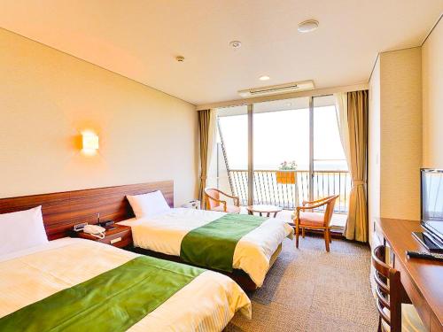 岛原市Hotel Seaside Shimabara的酒店客房设有两张床和电视。