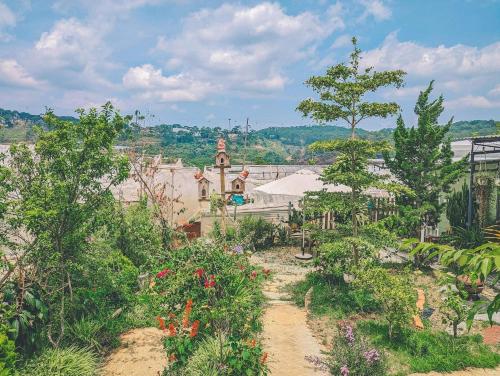 大叻Lem Homestay Đà Lạt的鲜花盛开的花园以及背景建筑