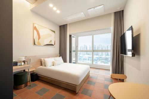 始兴市Le collective Siheung Wavepark的酒店客房设有一张床和一个大窗户