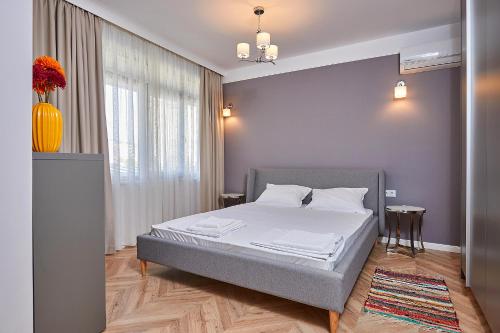 圣弗拉斯Florance Rentals Luxury Apartments in Saint Vlas的一间卧室配有床和花瓶