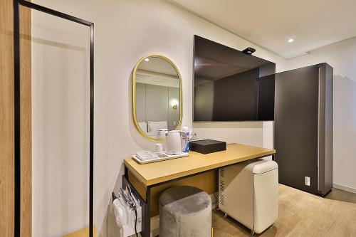 蔚山Hotel Rubato Ulsan Jung-gu Haksung的浴室配有带镜子的梳妆台和盥洗盆