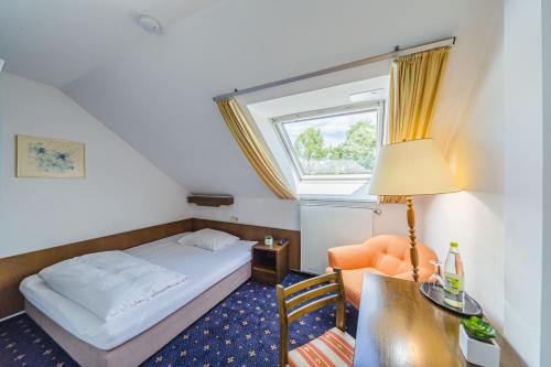 福希海姆弗兰肯酒店的一间卧室配有一张床、一张书桌和一个窗户。