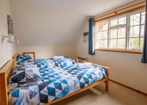 TomichPheasant Lodge的一间卧室设有两张床和窗户。