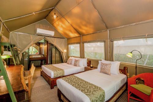 塞友桂河断山谷恒夺帐篷酒店的一间帐篷内带两张床的卧室