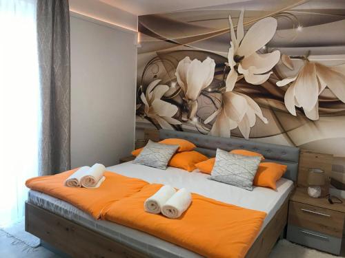KiszomborTó- Party Panoráma Panzió & Wellness的一间卧室配有带橙色和白色毛巾的床