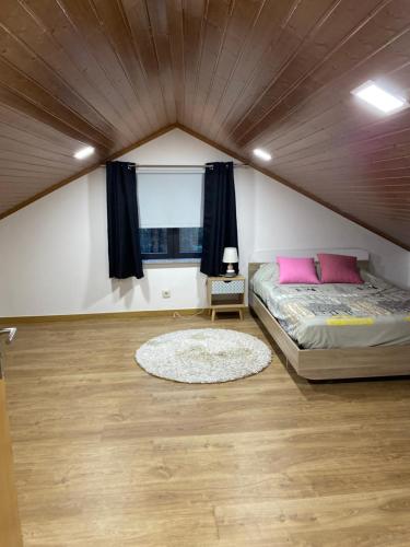 维拉·雷阿尔Moradia Activ Mar\Vão的一间卧室配有带粉红色枕头的床和窗户。