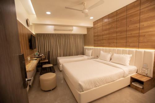 孟买Hotel Naaz Executive的酒店客房设有白色的床和浴室。