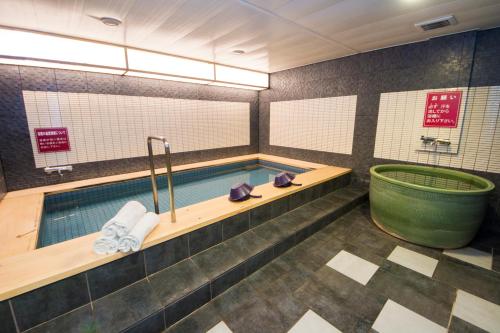 磐城岩城大公园酒店的一间带游泳池和浴缸的浴室