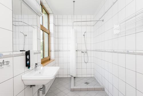 派尔努Kurgo Villa self check-in hotel的白色的浴室设有水槽和淋浴。