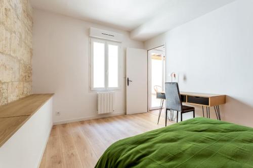 洛尔蒙Joli appartement avec jardin / Vieux-Lormont的白色卧室配有书桌和床