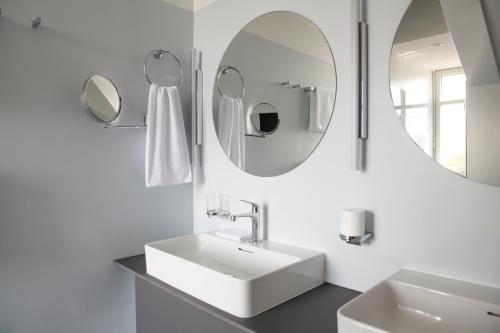 莱茵费尔登苏曾莱茵费尔登酒店的白色的浴室设有水槽和两面镜子
