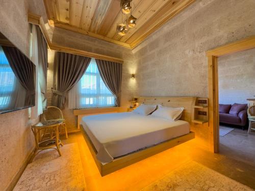 阿瓦诺斯Konak Ballıca - Deluxe Suite的一间卧室配有一张床和一个沙发