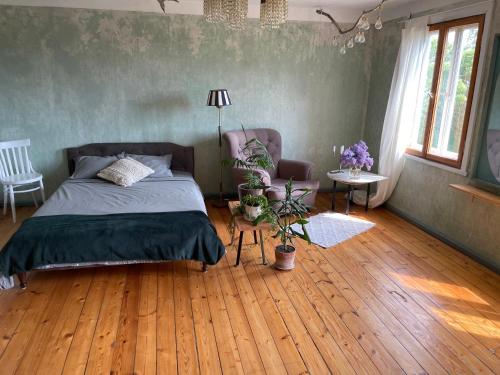JūrmalciemsKatrina Summer House的一间卧室配有一张床,铺有木地板