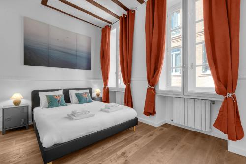 图卢兹Lucena - Charmant appt en centre-ville的一间卧室配有橙色窗帘的床