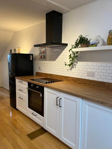 杜伦Homely 2 Story Cathedral City Apartment的厨房配有白色橱柜和黑色冰箱。