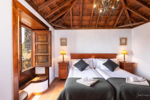马佐Lightbooking La Morita Villa de Mazo con piscina的一间卧室配有一张床和一个吊灯