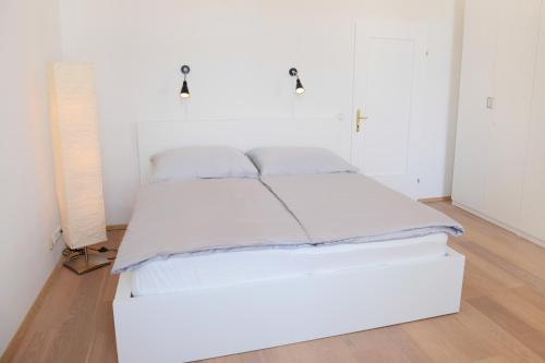 格蒙登Apartment am Traunsee的白色墙壁的房间里一张白色的床