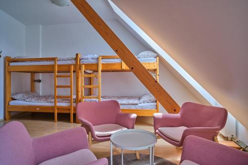卡姆尼克Samostan Mekinje的客房设有两张双层床、椅子和桌子。