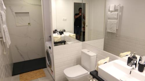 马德里Galileo apartment的一间带卫生间、水槽和镜子的浴室