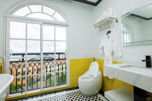 富国De Stefano Coffee and Hotel的一间带水槽和卫生间的浴室以及窗户。