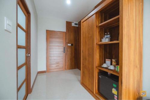 素可泰Na Sukhothai Hotel的走廊设有木制衣柜和门