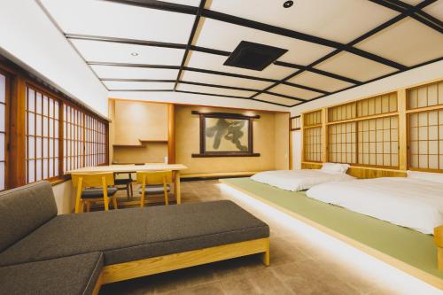 ŌdaRyokan Masuya的酒店客房设有两张床和一张桌子。