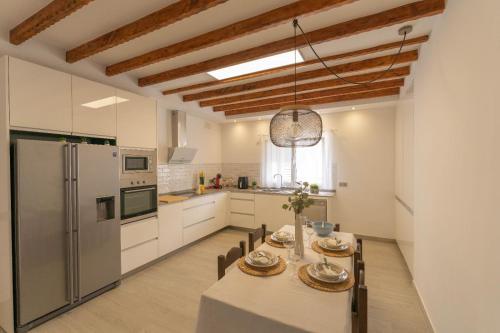 大加那利岛拉斯帕尔马斯Finca Artiles的厨房以及带桌子和冰箱的用餐室