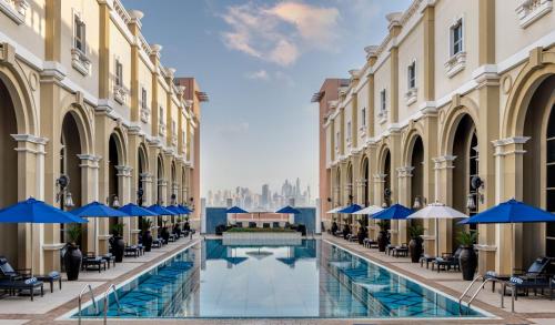 迪拜Oaks Ibn Battuta Gate Dubai的享有带椅子和遮阳伞的建筑庭院的景色