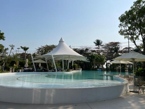 乔木提恩海滩Copacabana jomtien beach high floor的一个带遮阳伞的游泳池和一个游泳池