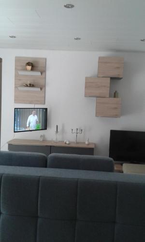 施特龙贝格Kleines Landhaus的客厅配有蓝色椅子和平面电视